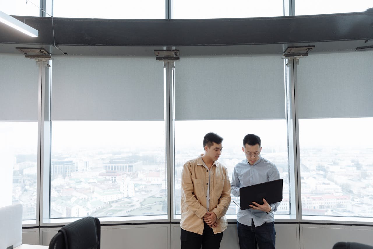 Two professionals discussing business strategy with a laptop in a modern office.